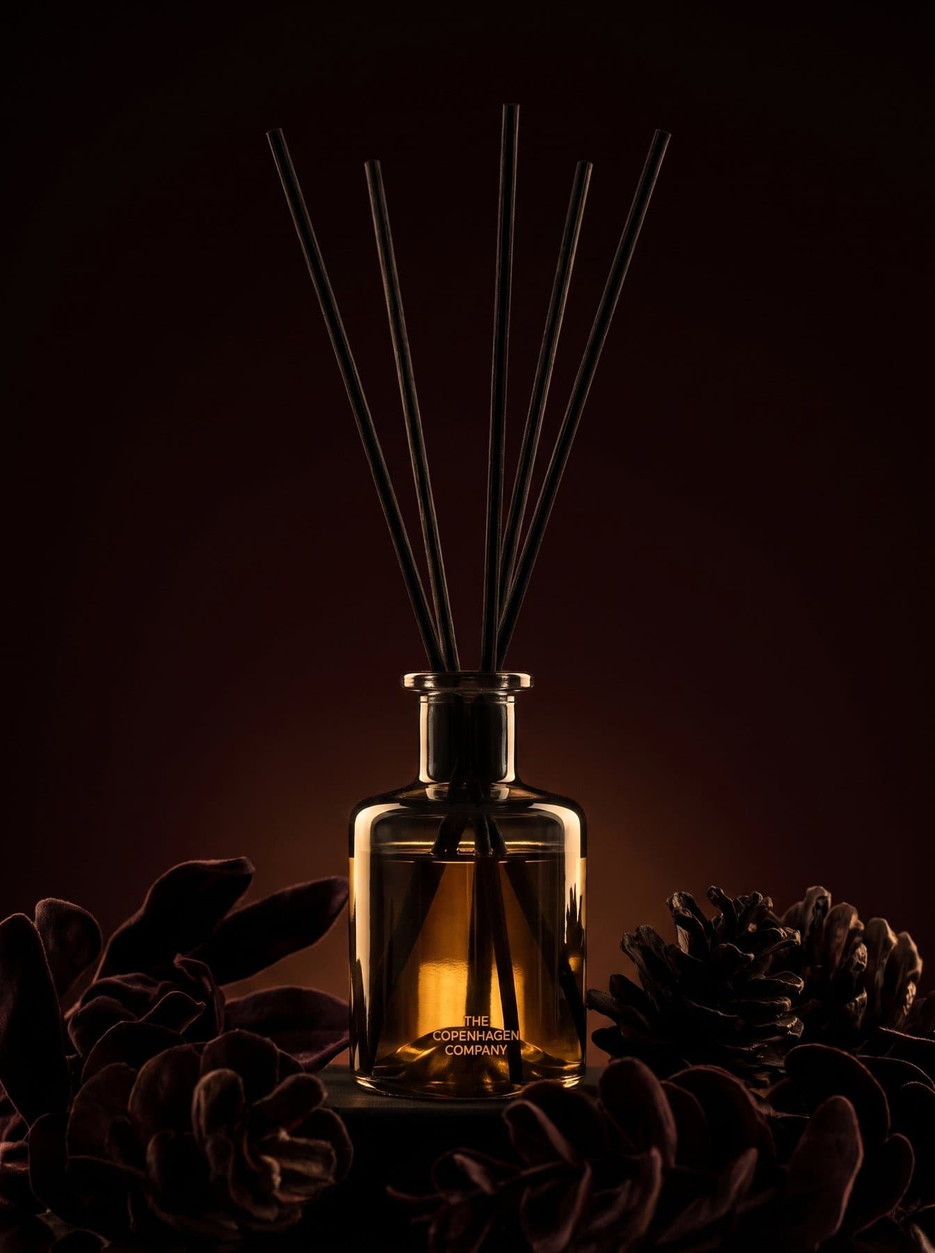 An Oud diffuser among pine cones