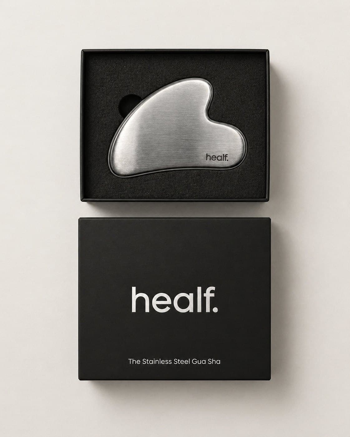 The steel gua sha in its black box