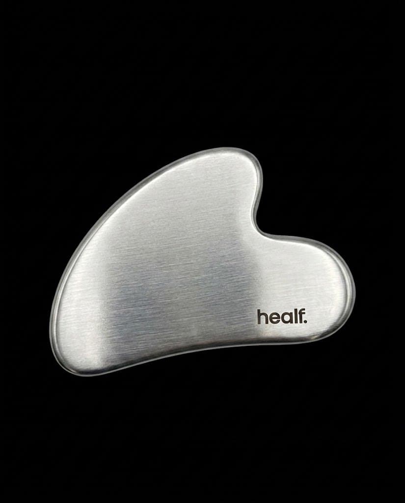 The steel gua sha, the mark printed, on black